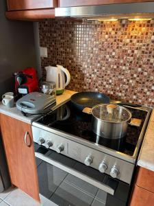 Una cocina con una estufa con ollas y sartenes encima. en Little Diamond Stay, en Mytilini 5 fotos más