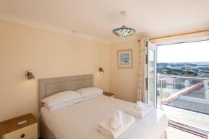a bedroom with a bed and a large window at Sandy Bay Apartment, St Ives Bay, Hayle in Hayle