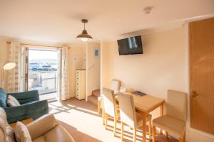a living room and dining room with a table and a couch at Sandy Bay Apartment, St Ives Bay, Hayle in Hayle