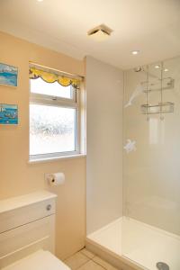 a bathroom with a shower and a window at Sandy Bay Apartment, St Ives Bay, Hayle in Hayle +14 photos