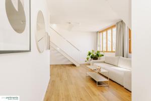 ein weißes Wohnzimmer mit einer weißen Couch und einer Treppe in der Unterkunft 139 QM - Exklusiv auf 2 Etagen - Werse Loft by youpartments in Münster + 37 Fotos