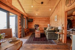 a living room with a couch and a table at Chestnut - Tedstone Log Cabins in Bromyard
