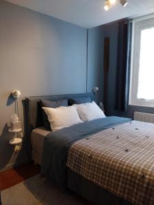 a bedroom with a bed with blue walls and a window at La Cabane du Pecheur in Honfleur