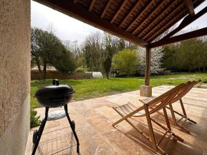 una griglia seduta su un patio accanto a una sedia di La Maison des Papillons - Nargis a Nargis