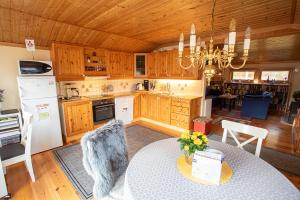 a kitchen with wooden cabinets and a table and a dining room at Iverhjelen Near Atlantic Road in Lyngstad