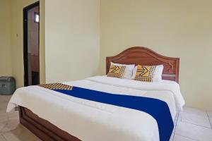 Ένα ή περισσότερα κρεβάτια σε δωμάτιο στο Hotel O Arfan HouseNearDanau Ranau