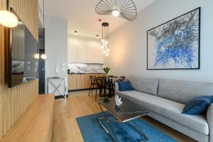a living room with a couch and a table at Nad zatoką Ukiel apartamenty przy jeziorze in Olsztyn