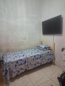 a bedroom with a bed and a flat screen tv at Doce Lar 58- Casa Evento in Cabo de Santo Agostinho