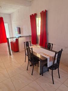 a dining room with a table and chairs and red curtains at Doce Lar 58- Casa Evento in Cabo de Santo Agostinho