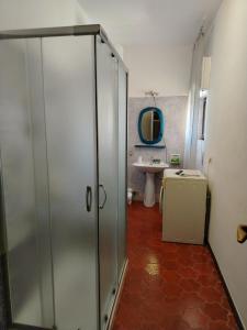 un bagno con doccia in vetro e lavandino di A due passi dal mare ad Alghero