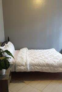 a bed with white sheets on it in a room at MOA Homes in Kampala