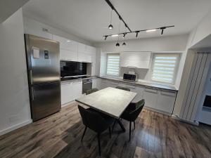 a kitchen with a table and chairs and a refrigerator at Carol Apart in Craiova