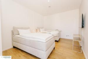 ein weißer Raum mit einer Couch und einem Sessel in der Unterkunft 139 QM - Exklusiv auf 2 Etagen - Werse Loft by youpartments in Münster