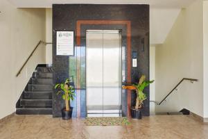 an elevator in a building with two potted plants at Treebo Premium Ocean Echo, Rushikonda in Rushikonda