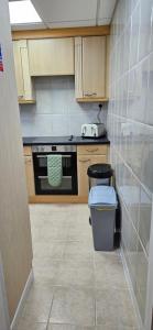 a kitchen with a stove and a trash can at Barton Beach First Floor Holiday Apartment Mablethorpe in Mablethorpe