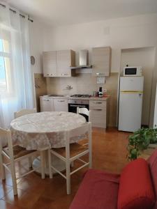 una cucina con un tavolo e un frigorifero bianco di A due passi dal mare ad Alghero