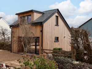 a wooden house with a black roof at The Cabin at Ropewalk in St. Agnes