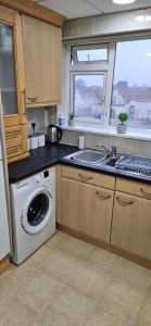 a kitchen with a washing machine and a sink at Barton Beach First Floor Holiday Apartment Mablethorpe in Mablethorpe