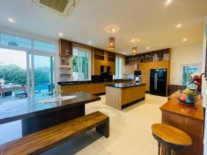 a large kitchen with a bench and a table at Sea View Luxury Mansion, Pool & Jacuzzi - Koh Chang in Ko Chang