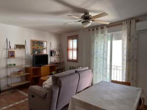 a living room with a couch and a ceiling fan at casalapita in Carboneras