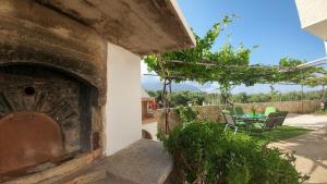 a patio with a table and chairs and a brick oven at Eva's House in Kissamos