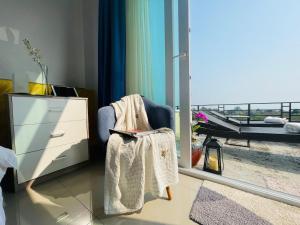 a bedroom with a chair with a dresser and a balcony at Sea View Luxury Mansion, Pool & Jacuzzi - Koh Chang in Ko Chang