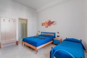 a bedroom with two beds with blue sheets at B&B Gioia del Mare in Torre Lapillo