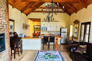 a kitchen and living room with a chandelier at Stonehaven Cottage in Machadodorp