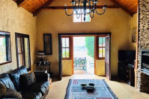 a living room with a couch and a chandelier at Stonehaven Cottage in Machadodorp