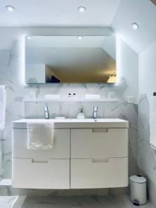 a white bathroom with a sink and a mirror at Ici, dort un Yeti in Planay +13 photos