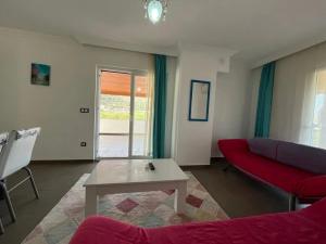 a living room with a red couch and a table at Elfida Apart in Datca