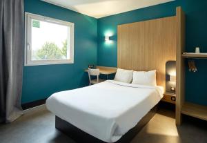a bedroom with a bed and a table and a window at B&B HOTEL Evry Lisses 2 in Lisses +45 photos