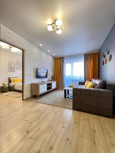 a living room with a couch and a television at Квартира подобово Центр Руська in Ternopilʼ