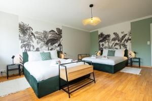 two beds in a room with green walls at Évasion à Oiry Villa Madeline in Oiry