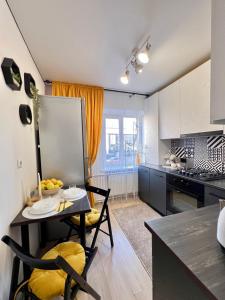 a kitchen with a table with a bowl of fruit on it at Квартира подобово Центр Руська in Ternopilʼ