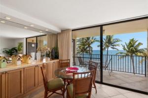 a dining room with a table and a view of the ocean at Kihei Beach, #603^ condo in Kihei