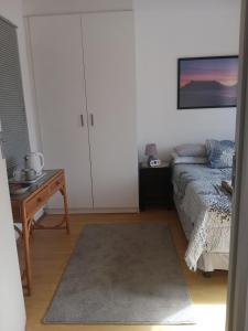 a bedroom with a bed and a table with a table sidx sidx at Home in Bellville, Cape Town in Victory Hill +1 photo