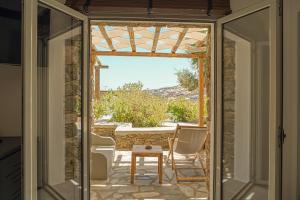 een glazen deur naar een patio met een tafel en stoelen bij Santa Maria Hotel in Elia Beach