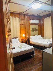 a small room with two beds and a door at No5 Hostel Songkhla in Songkhla