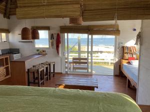 a kitchen and living room with a view of the ocean at Cabañas Punta Papaya in Punta Del Diablo +58 photos