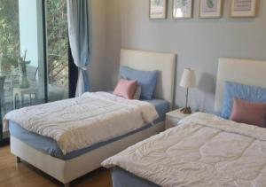 Ban Talungสวนภาคินรัตน์的一间卧室，配有两张床和一扇窗户