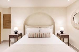 a bedroom with a large white bed with two night stands at Kohili Villas in Skopelos Town +101 photos
