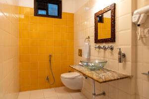 a bathroom with a sink and a toilet and a mirror at Udaigarh - Udaipur in Udaipur +42 photos