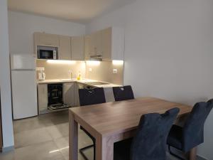 a kitchen with a wooden table and blue chairs at ORCHIDEA PREMIUM Apartment in Hévíz