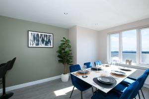 a dining room with a table and blue chairs at Penthouse River View near Edinburgh in Saint Davids