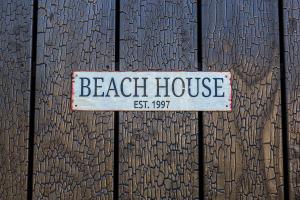 a sign that reads beach house on a wooden fence at Beach House in Lège-Cap-Ferret