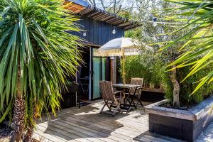 a patio with a table and chairs and an umbrella at Beach House in Lège-Cap-Ferret