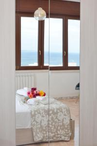 a table with flowers on it in a room with windows at Tropical Paradise x AP Apartment in Gallipoli