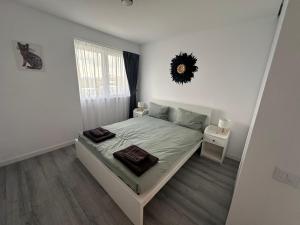 a white bedroom with a bed and a window at Myhouse 2 in Ploieşti