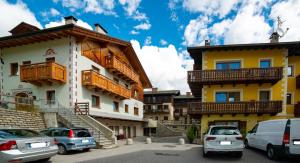 a group of buildings with cars parked in a parking lot at Appartamenti Alba in Livigno